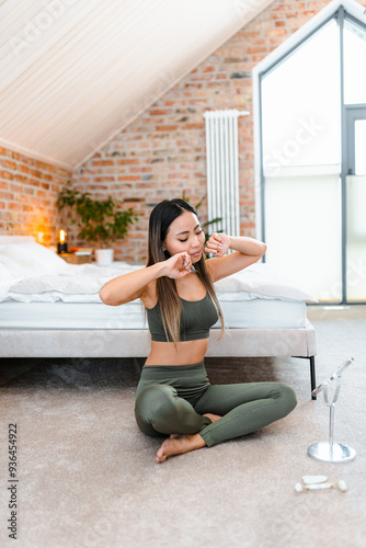 A woman does a facial massage with her hands and looks in the mirror. She's sitting on the bedroom floor Free Download A woman does a facial massage with her hands and looks in the mirror. She's sitting on the bedroom floor - GFXLoad
