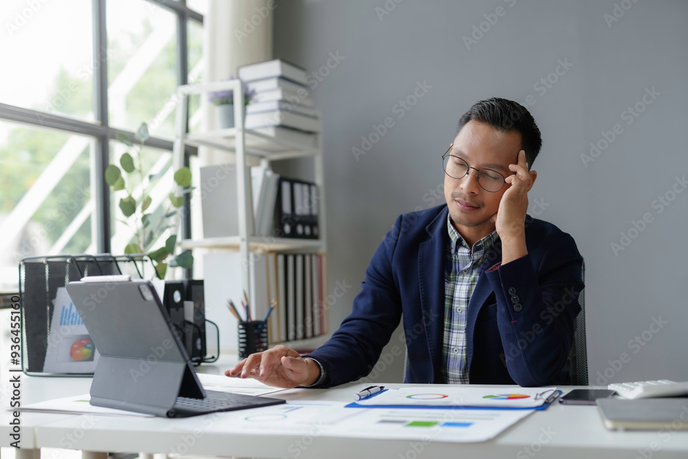 Exhausted manager suffering from headache while working with financial data and using laptop in modern office Exhausted manager suffering from headache while working with financial data and using laptop in modern office
