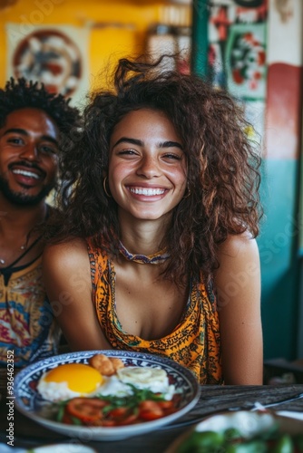 A joyful woman enjoying a delicious pasta dish with a smiling companion at a ...