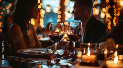 Elegant couple sharing a kiss at a candlelit dinner with wine glasses on a luxurious evening. Soft lighting and romantic ambiance make it perfect for date night and celebration themes.
