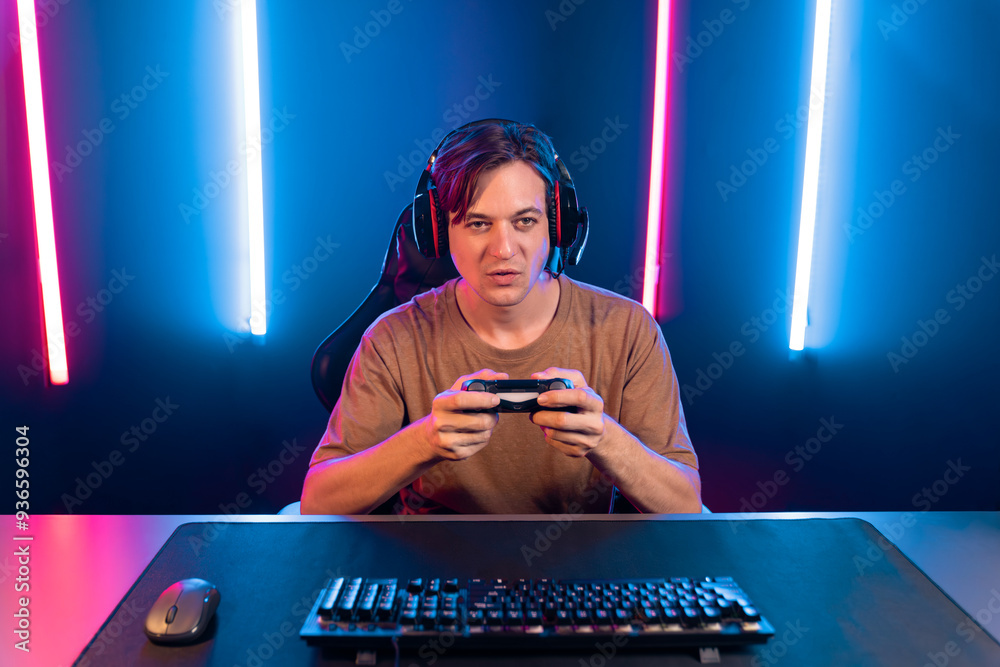 Enjoy smart gaming streamer with control joystick, playing game online of live streaming social media group with team skilled players on computer at modern technology cyber neon light room. Pecuniary. Enjoy smart gaming streamer with control joystick, playing game online of live streaming social media group with team skilled players on computer at modern technology cyber neon light room. Pecuniary.