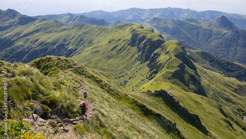 Randonneur en été dans le Cantal, sentier de randonnée entre le Puy Mary et la brèche de Rolland avec panorama sur les sommets cantaliens photo
