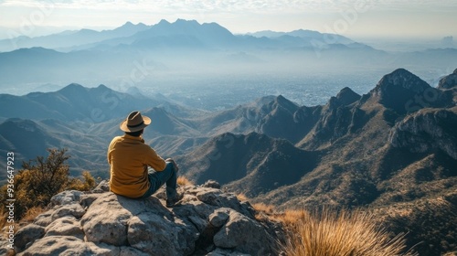 Person enjoying a panoramic view of mountains and valley on a sunny day