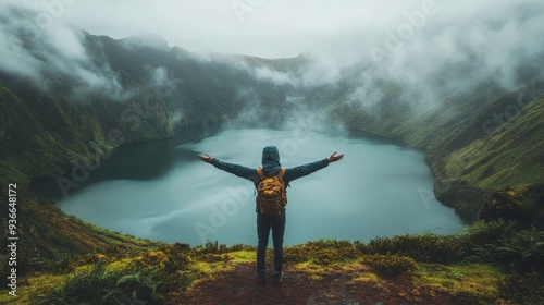 Person in yellow raincoat stands with arms outstretched by a serene volcanic ...