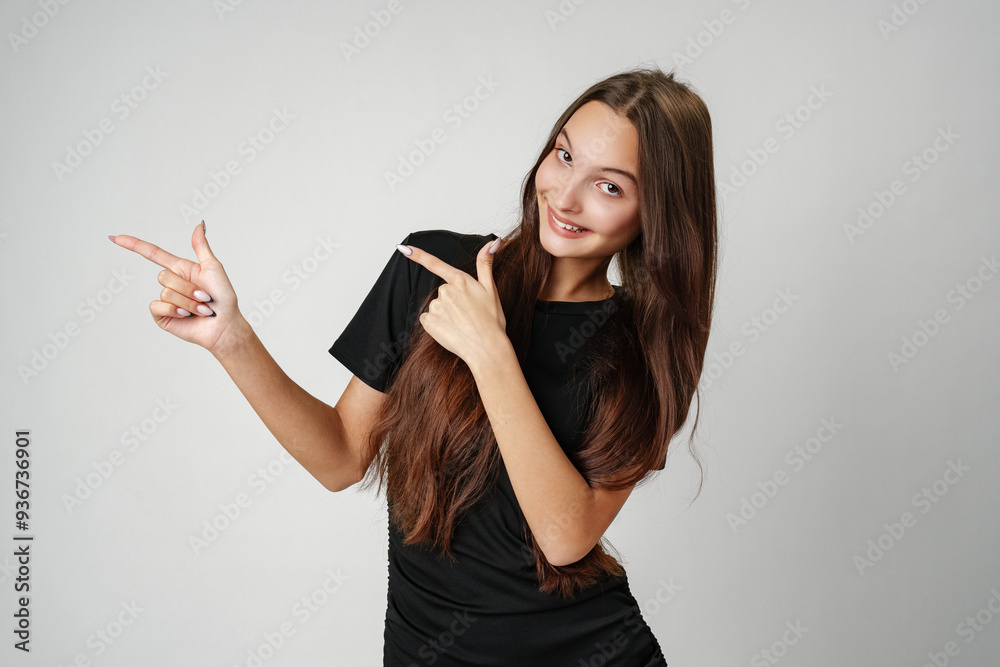Young Woman Pointing to Copy Space Against a Light Background Young Woman Pointing to Copy Space Against a Light Background