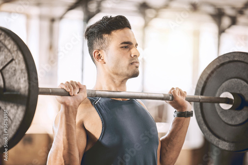 Serious, man and bodybuilder with barbell in gym for weightlifting, workout and strength training. Athlete, power and person with muscle exercise at health club for fitness, challenge and endurance