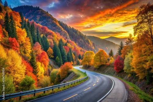 Vibrant autumn colors surround a winding black asphalt road as it stretches through a scenic mountainous landscape at sunset, capturing the essence of Germany's fall beauty. photo