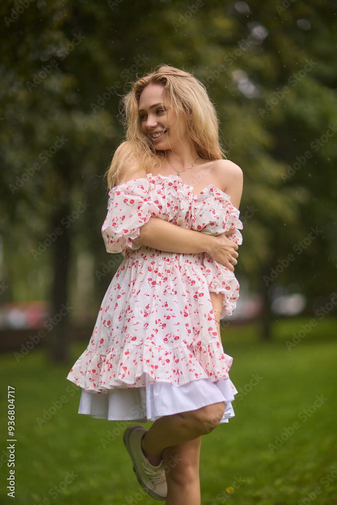A Beautiful and Elegant Young Woman in a Lovely Summer Dress Posing Gracefully Outdoors A Beautiful and Elegant Young Woman in a Lovely Summer Dress Posing Gracefully Outdoors