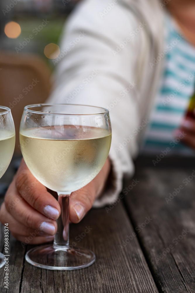 Obraz premium Tasting of Bordeaux white wine, right bank of Gironde Estuary, France. Glasses of white sweet French wine served in outdoor restaurant