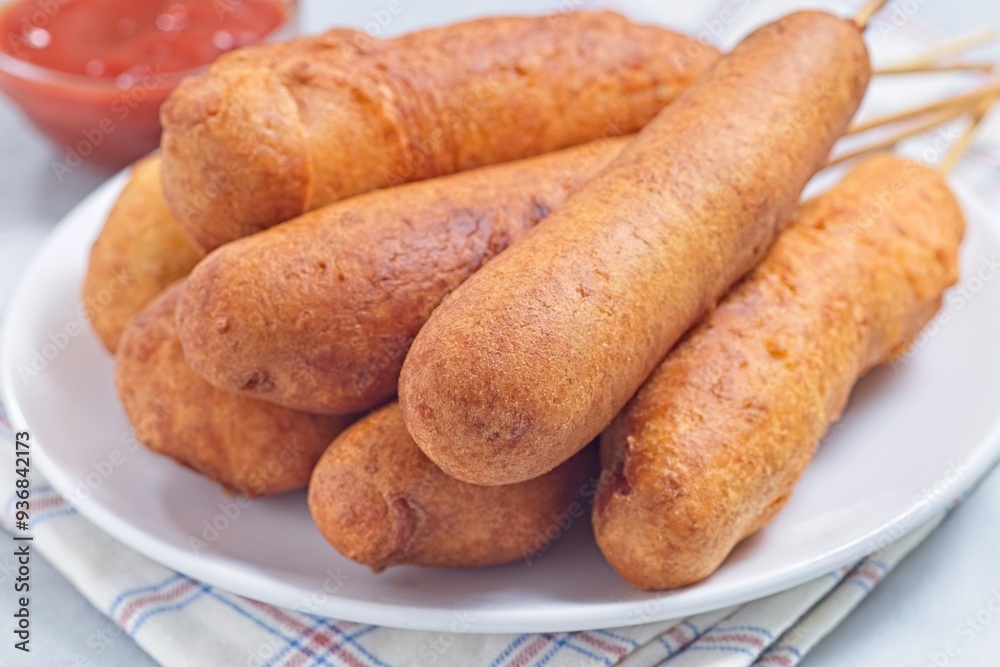 Heap of corn dogs on white plate, served with ketchup, horizontal Heap of corn dogs on white plate, served with ketchup, horizontal