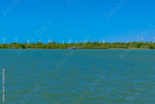 VIEW OF THE JAGUARIBE RIVER IN THE MUNICIPALITY OF FORTIM ON THE EAST COAST OF THE STATE OF CEARÁ WITH A RENEWABLE ENERGY WIND FARM UNDER THE SAND DUNES IN THE BACKGROUND. photo