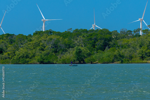 VIEW OF THE JAGUARIBE RIVER IN THE MUNICIPALITY OF FORTIM ON THE EAST COAST OF THE STATE OF CEARÁ WITH A RENEWABLE ENERGY WIND FARM UNDER THE SAND DUNES IN THE BACKGROUND. photo