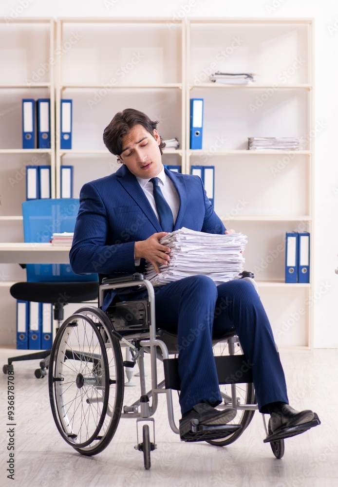 Young male employee in wheelchair working in the office Young male employee in wheelchair working in the office