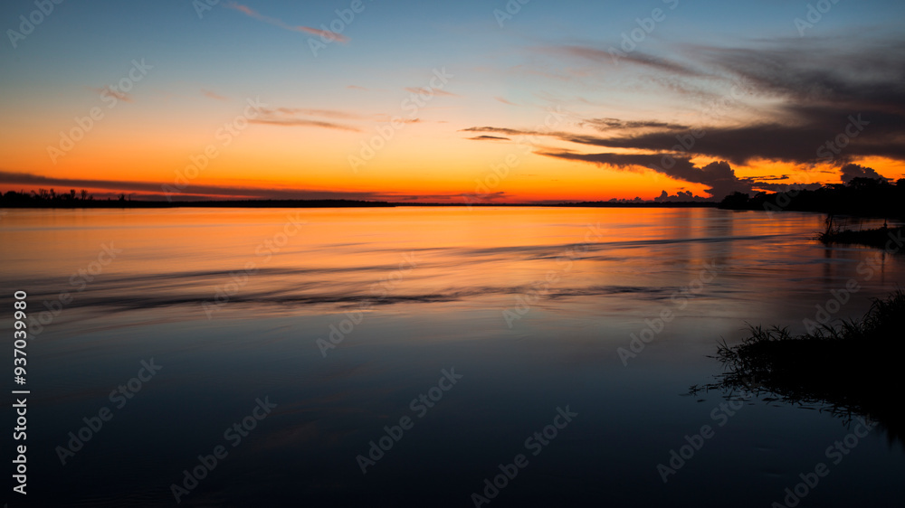 Golden hour over calm river and horizon Golden hour over calm river and horizon