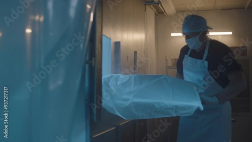 A Mortician taking the body out from the freezer
