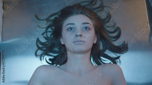 Directly above a female corpse on the table