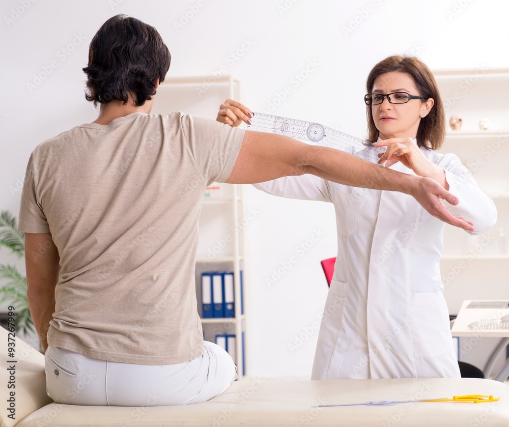 Fototapeta premium Female doctor checking patient's joint flexibility with goniomet