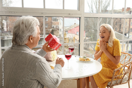Mature man giving gift to h...