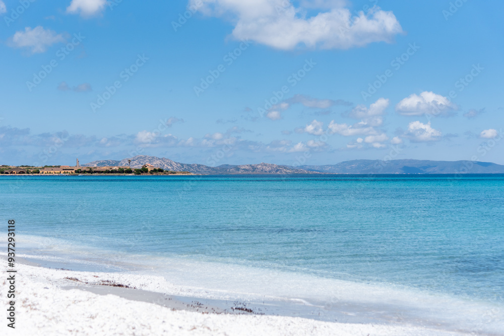 Le Saline beach landscape: turquoise sea meets a distant horizon with faint landforms, under a vast blue sky. A breathtaking view capturing the serene beauty of Sardinia's coastline. Le Saline beach landscape: turquoise sea meets a distant horizon with faint landforms, under a vast blue sky. A breathtaking view capturing the serene beauty of Sardinia's coastline.