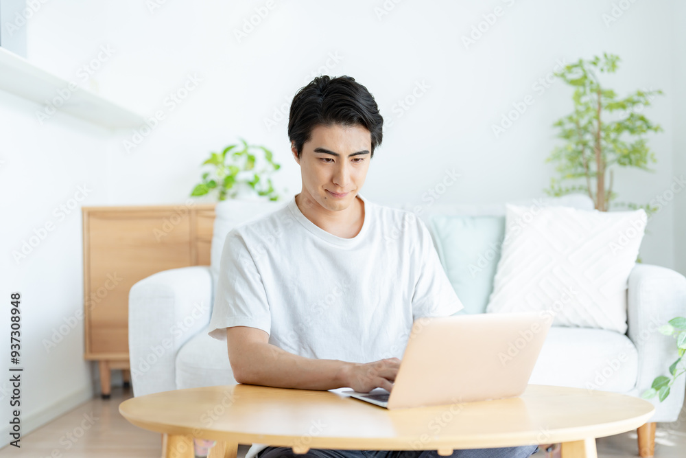 自宅でパソコン作業をする爽やかな男性 自宅でパソコン作業をする爽やかな男性