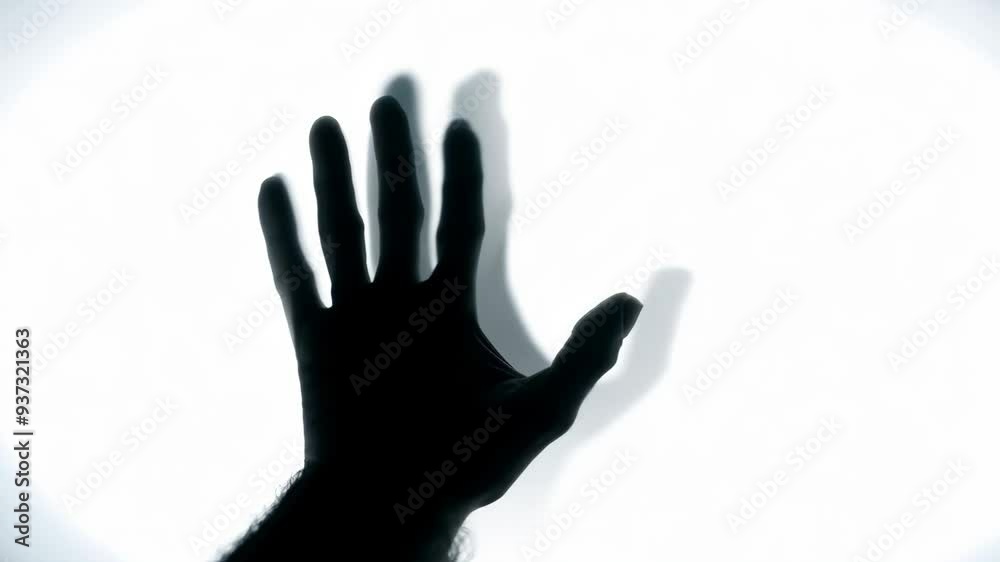 Eerie shadow of a zombie hand on a white background in horror theme Eerie shadow of a zombie hand on a white background in horror theme