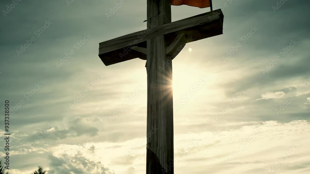 Sunset casts dramatic light on tall wooden cross amid serene forest landscape