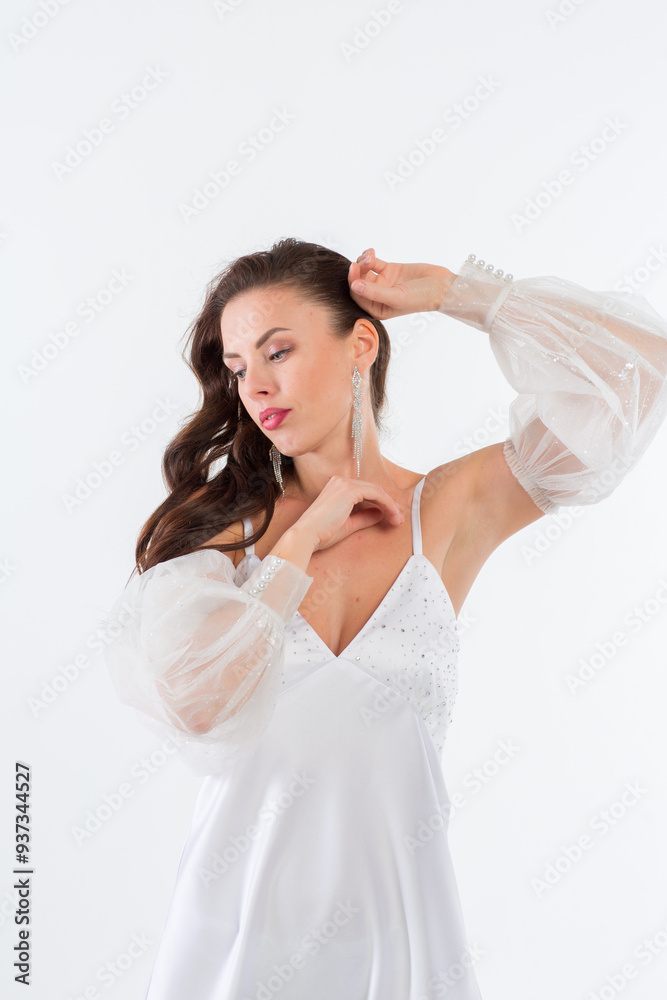 A young girl in a beautiful white dress in a white photo studio. A young girl in a beautiful white dress in a white photo studio.
