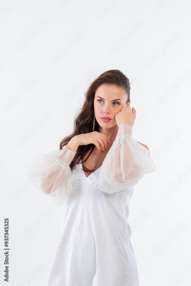 A young girl in a beautiful white dress in a white photo studio. A young girl in a beautiful white dress in a white photo studio.