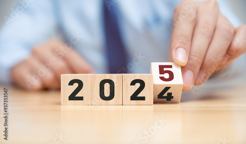 New project growth concept in 2025, Preparation for happy new year , Hand of man flip wooden cube from 2024 to 2025.