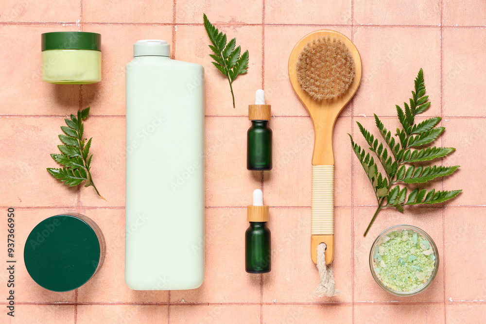 Composition with different cosmetic products, massage brush and fern leaves on color tile background