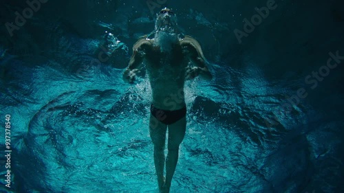 Directly below a man swimmer in the pool