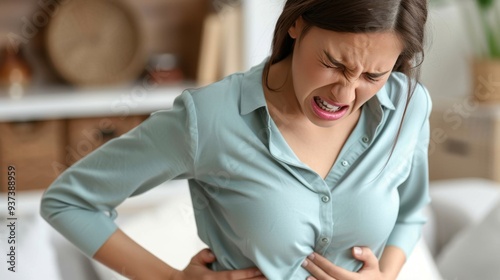 Woman clutching her rib cage with a pained facial expression.
