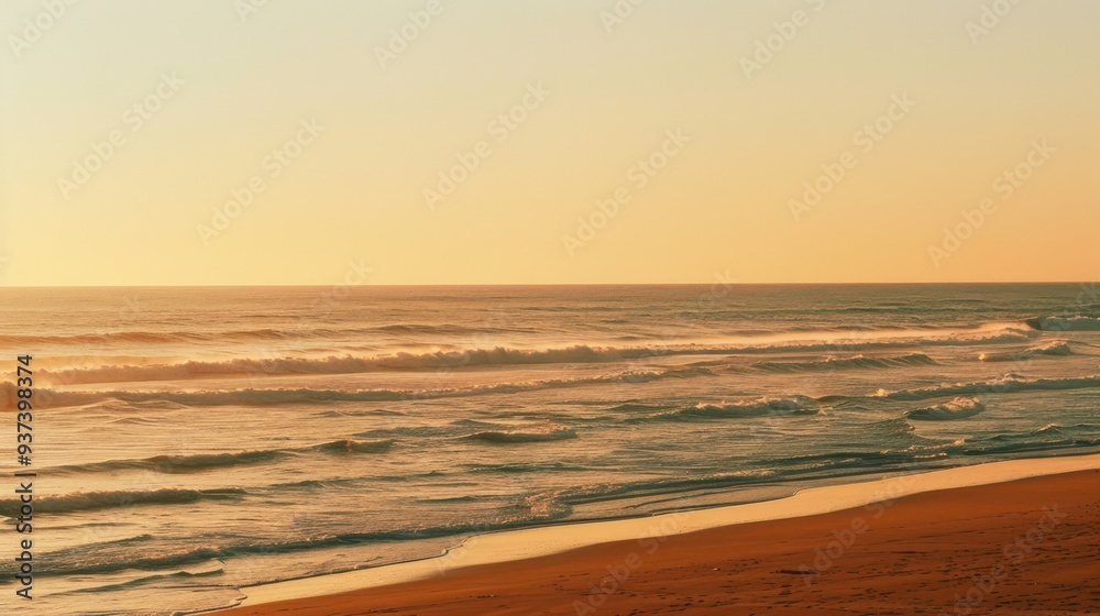 Obraz premium Ocean Waves Crashing on a Sandy Beach at Sunset