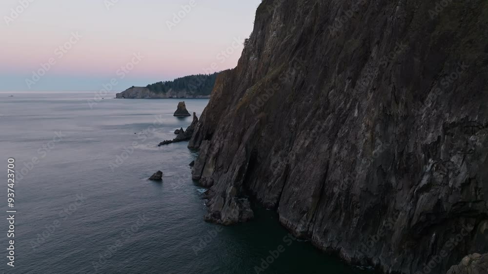 Static aerial overview of the Oregon Coast with sea cliffs dropping in flakes into water, early morning dawn Static aerial overview of the Oregon Coast with sea cliffs dropping in flakes into water, early morning dawn