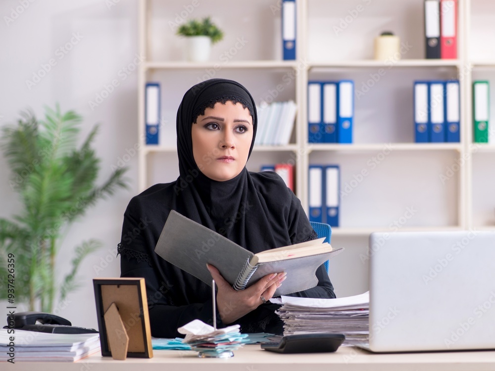 Female employee bookkeeper in hijab working in the office