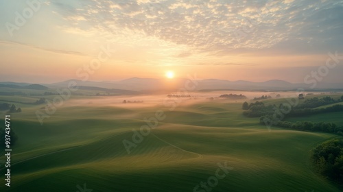 Sunrise over rolling hills and a misty valley.