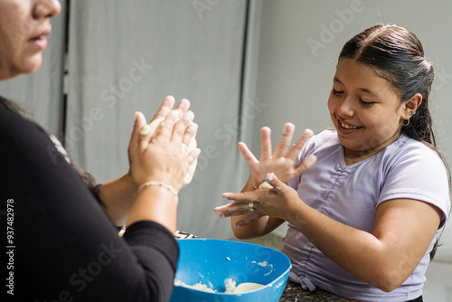 Cooking arepas: mother and daughter enjoy the process and time spent together in the kitchen. The daughter, attentive and enthusiastic, actively participates in the cooking process. 