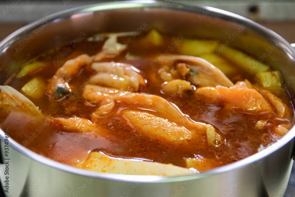 Pot of yellow curry with salmon and bamboo shoot thai southern style food.