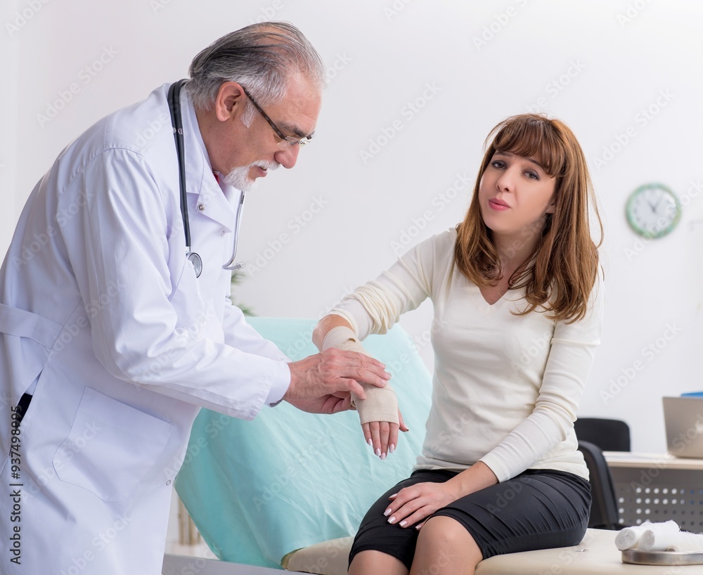 Obraz premium Young injured woman visiting experienced doctor traumatologist