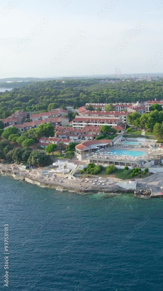 A stunning vertical (reel)view captured by drone along the shores of the Mediterranean Sea. The beautiful Croatian coast during a summer vacation, with boats and yachts slicing through the sea waters. A stunning vertical (reel)view captured by drone along the shores of the Mediterranean Sea. The beautiful Croatian coast during a summer vacation, with boats and yachts slicing through the sea waters.