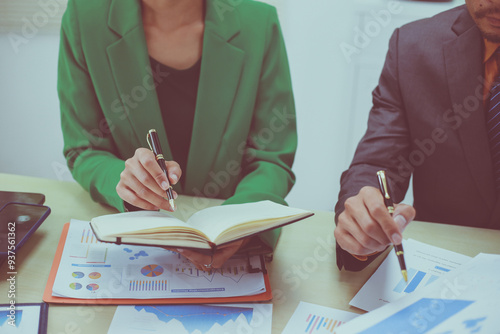 A group of professional business men and women are having a constructive meeting, discussing strategies, exchanging ideas and making decisions in a modern organization. They are wearing formal suits.
 photo