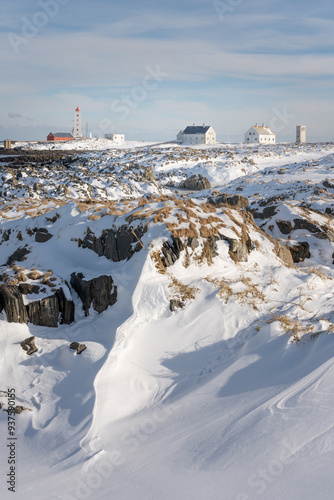 A lighthouse on the rugged coast of the Arctic Ocean in Varanger Peninsula, Northern Norway on a freezing cold winter day photo