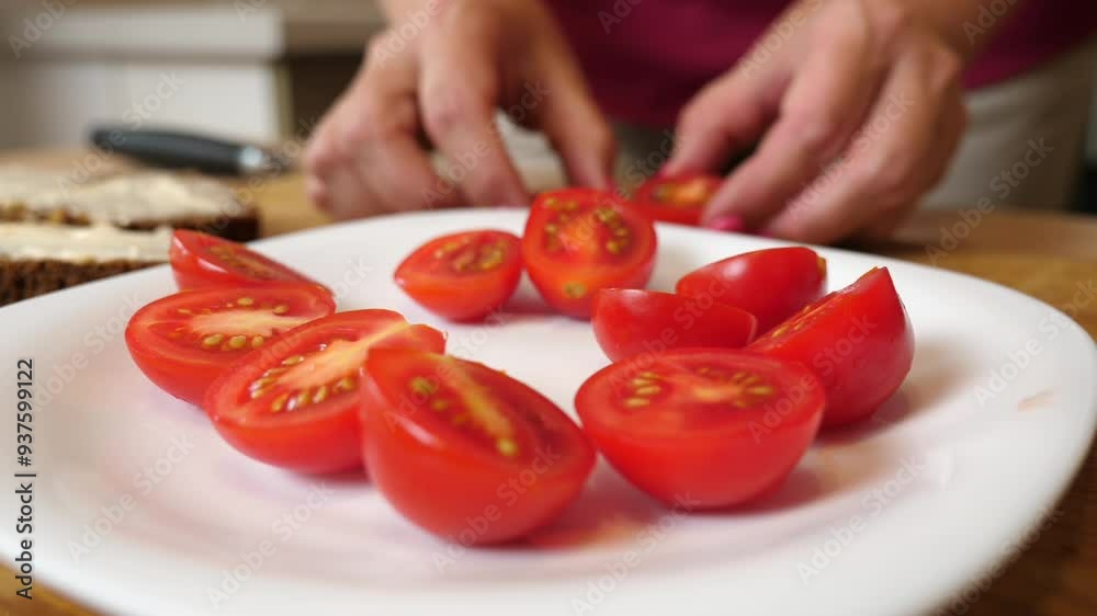 To prepare the dish, cherry tomatoes are cut in half with a knife. To prepare the dish, cherry tomatoes are cut in half with a knife.
