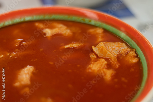 Fototapeta Naklejka Na Ścianę i Meble -  A traditional Mexican beef stomach menudo soup, with a rich red broth and tender chunks of beef in a bowl from an authentic Mexican food restaurant
