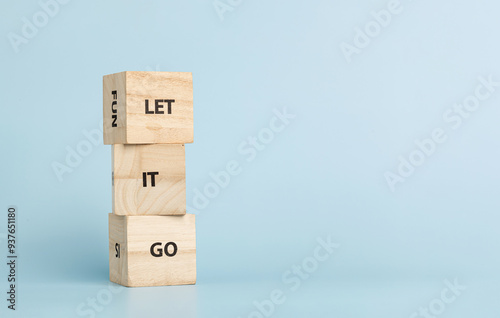 Fotografia Wooden cubes with inscriptions Let It Go on a blue background