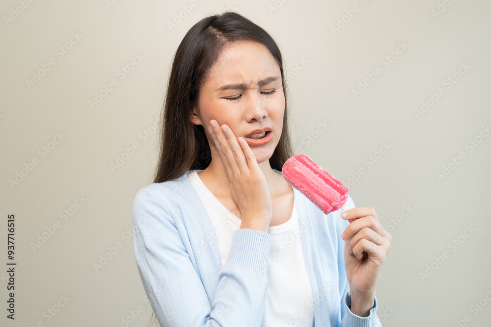 Face expression suffering from sensitive teeth, Asian young woman touching cheek Face expression suffering from sensitive teeth, Asian young woman touching cheek