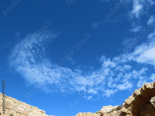 Beautiful view from the ruins of an ancient city in Caesarea in Israel to a blue sky and a crescent of white clouds. An interesting journey through historical sights.