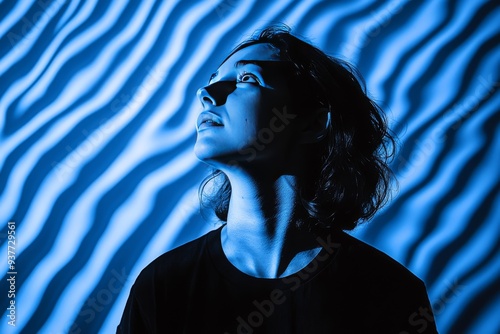 Profile of a man illuminated by blue and white striped lights symbolizing the fusion of modern digital experiences and human identity in a high tech world photo