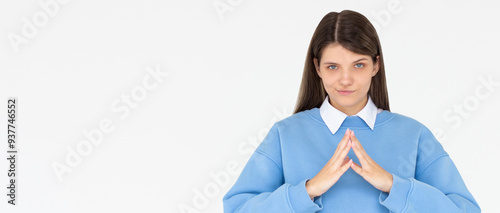 I have great evil plan. Confident and tricky woman in blue sweatshirt, holding fingers together and smirking at camera, having some bad intention in mind, planning to commit crime photo