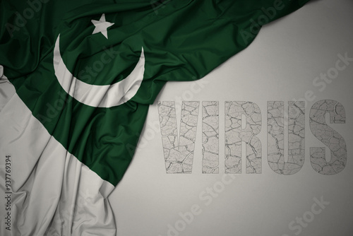 waving colorful national flag of pakistan on a gray background with text virus . photo